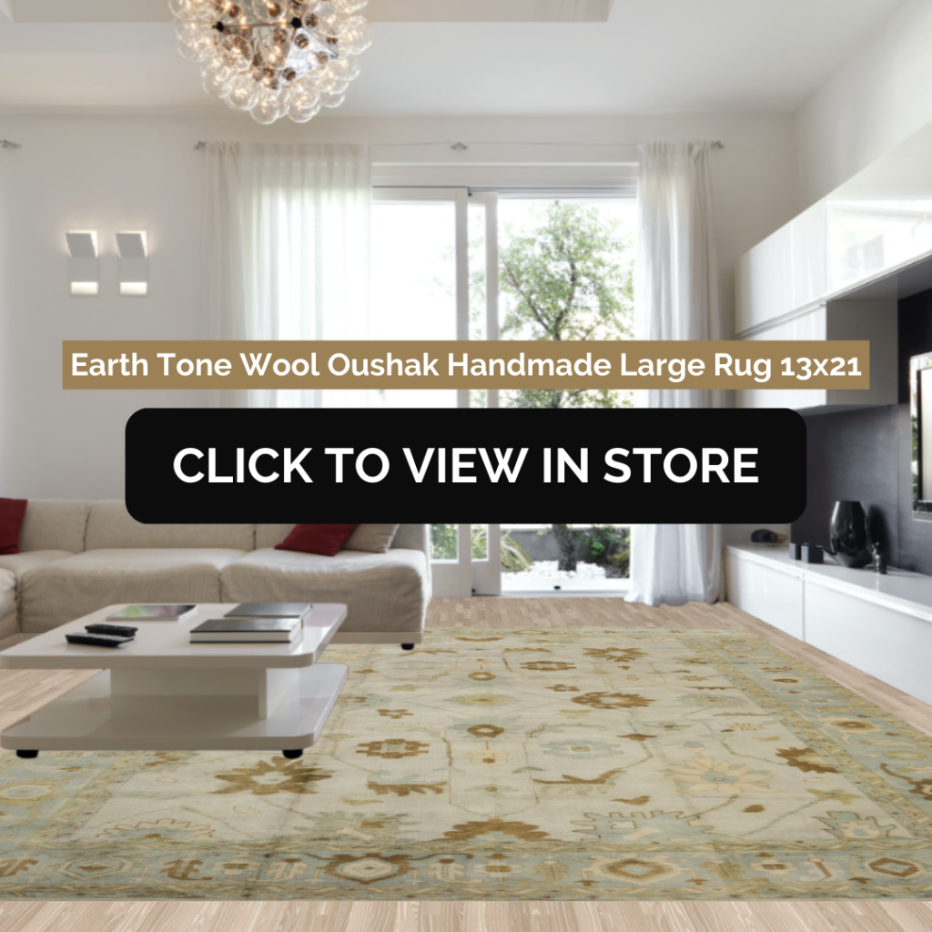 Contemporary white living room showcasing a luxurious 13x21 earth-tone wool Oushak handmade rug with intricate patterns, centered under a minimalist coffee table. Large windows and modern furnishings complete the elegant atmosphere.