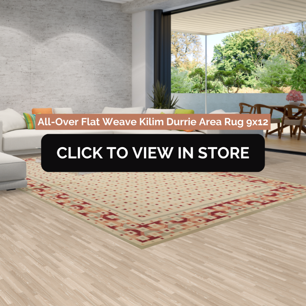 Modern living room featuring a vibrant 9x12 flat weave Kilim Durrie area rug with red and beige geometric patterns, positioned under a coffee table on light wood flooring. Large glass doors provide natural light and a view of a lush outdoor area.