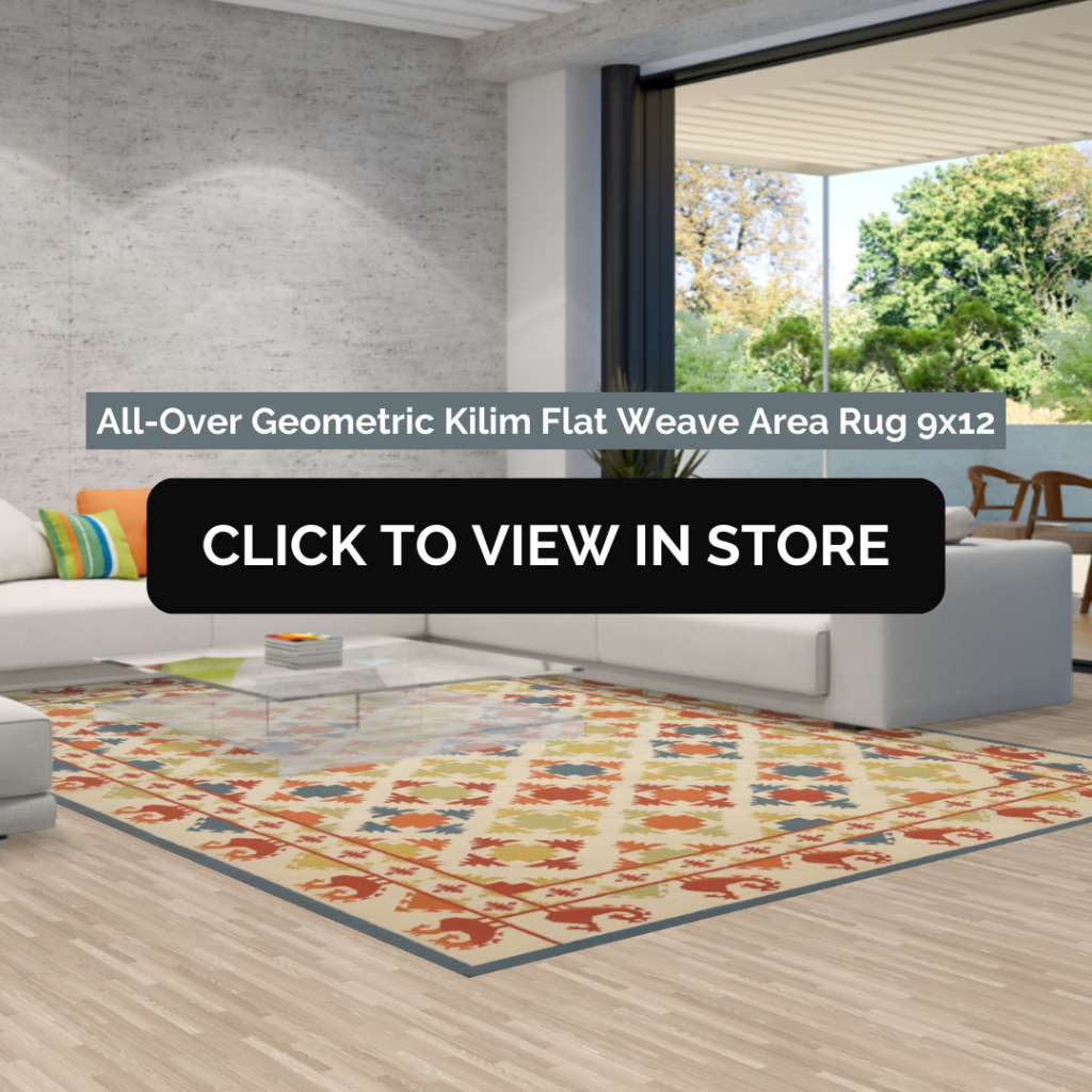 A All-Over Geometric Kilim Flat Weave Area Rug (9x12) in a contemporary open-concept living space with a neutral-toned sectional sofa and a sleek glass coffee table. The rug features an intricate geometric pattern with vibrant red, yellow, blue, and green hues on a beige background, enhancing the room's modern aesthetic with large windows and an outdoor view. The image includes text: "All-Over Geometric Kilim Flat Weave Area Rug 9x12" and a call-to-action button: "CLICK TO VIEW IN STORE."