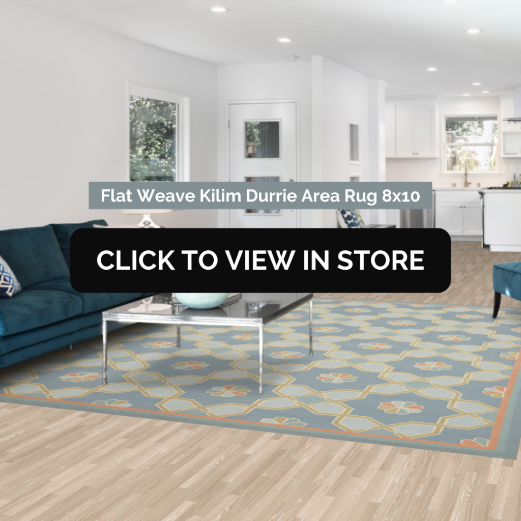 A Flat Weave Kilim Durrie Area Rug (8x10) in a modern living room with a teal sectional sofa and a glass coffee table. The rug has a geometric pattern in blue, gold, and beige tones with an orange border, complementing the room's light wood flooring and white walls. The image includes text: "Flat Weave Kilim Durrie Area Rug 8x10" and a call-to-action button: "CLICK TO VIEW IN STORE."