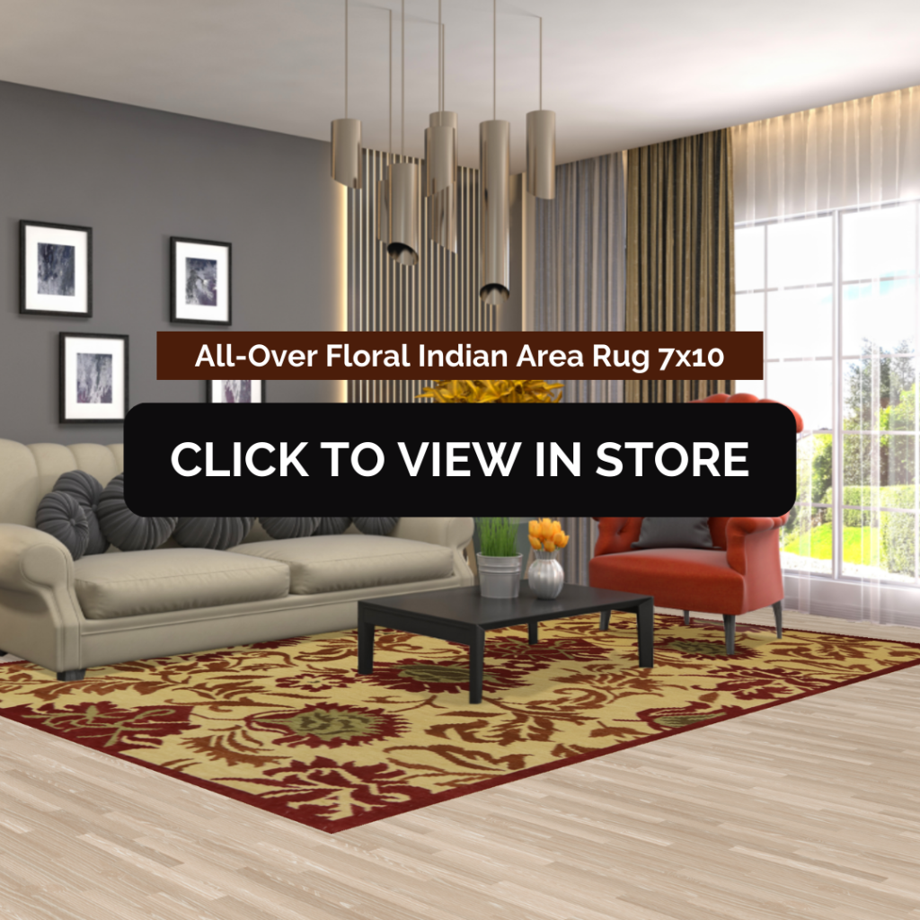 A stylish living space showcasing an All-Over Floral Indian Area Rug (7x10) with a bold floral pattern in red, beige, and gold tones. The space includes a neutral-toned sofa, a black coffee table, a red accent chair, pendant lighting, and framed artwork on the walls. The image contains text: "All-Over Floral Indian Area Rug 7x10" and a call-to-action button: "CLICK TO VIEW IN STORE."