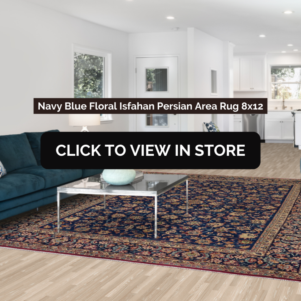 A contemporary living room featuring a Navy Blue Floral Isfahan Persian Area Rug (8x12) with intricate floral patterns in navy blue, beige, and red. The room has a minimalist design with a deep blue sectional sofa, a modern glass coffee table, and a bright open-concept kitchen in the background. The image includes text: "Navy Blue Floral Isfahan Persian Area Rug 8x12" and a call-to-action button: "CLICK TO VIEW IN STORE."