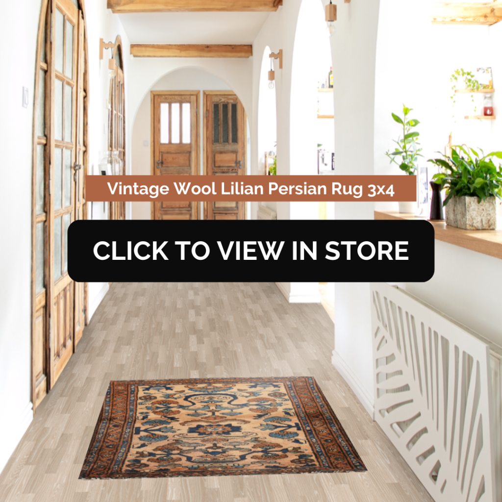 A beautifully designed hallway featuring a Vintage Wool Lilian Persian Rug (3x4) with intricate patterns in beige, navy blue, and rust tones. The space has a rustic-modern aesthetic with wooden ceiling beams, arched white walls, natural light, and warm wooden doors. The image includes text: "Vintage Wool Lilian Persian Rug 3x4" and a call-to-action button: "CLICK TO VIEW IN STORE."