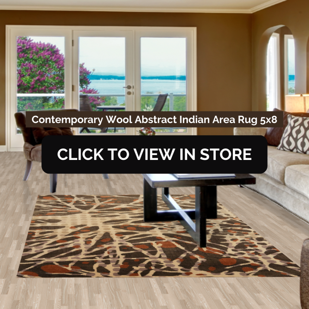 A stylish living room featuring a Contemporary Wool Abstract Indian Area Rug (5x8) with an organic, branch-like pattern in shades of brown, beige, and black. The space includes a beige sectional sofa with patterned pillows, a black coffee table, and large windows overlooking an outdoor patio with a scenic view. The image includes text: "Contemporary Wool Abstract Indian Area Rug 5x8" and a call-to-action button: "CLICK TO VIEW IN STORE."