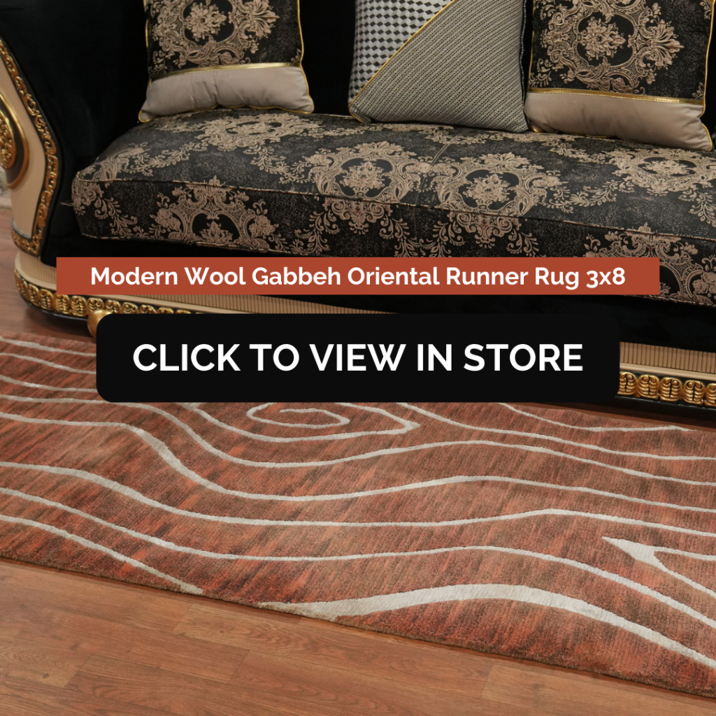 A luxurious living space with a black and gold ornate sofa adorned with patterned cushions. A modern wool Gabbeh Oriental runner rug (3x8) with a wavy pattern in shades of brown and beige lies on a wooden floor. The image includes text that reads: "Modern Wool Gabbeh Oriental Runner Rug 3x8" and a call-to-action button stating: "CLICK TO VIEW IN STORE."