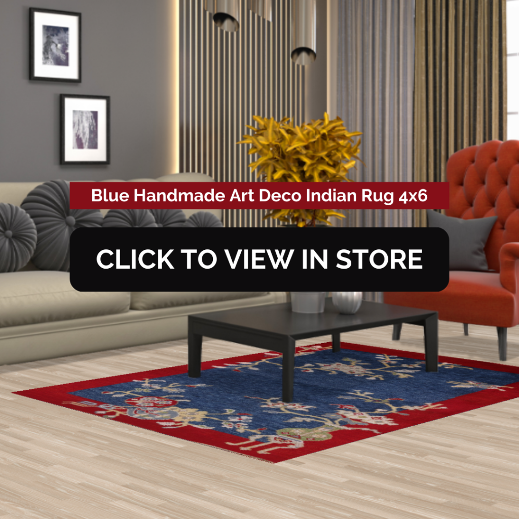 Blue Handmade Art Deco Indian Rug (4x6) displayed in a modern living room. The rug features a deep blue background with intricate floral motifs and a bold red border. It is placed under a sleek black coffee table, complementing the beige sofa with gray accent pillows and a red lounge chair. The room has contemporary decor with framed wall art, vertical wood paneling, and a warm ambiance. The image includes text: "Blue Handmade Art Deco Indian Rug 4x6" and a call-to-action button: "CLICK TO VIEW IN STORE."