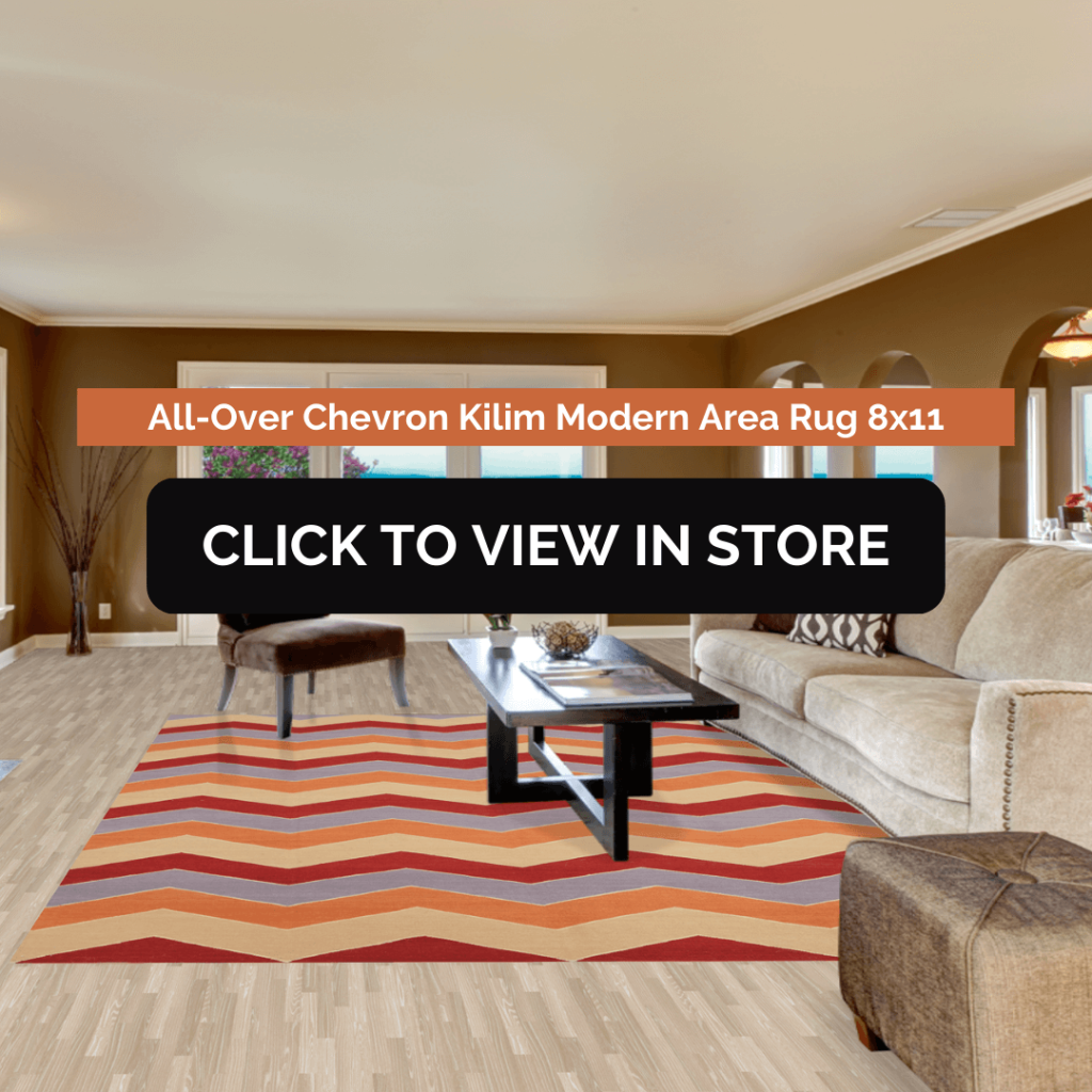 A spacious living room featuring a bold, chevron-patterned Kilim area rug in shades of red, orange, and beige. The rug is placed beneath a sleek black coffee table, with a beige sectional sofa and brown ottoman complementing the warm-toned decor.