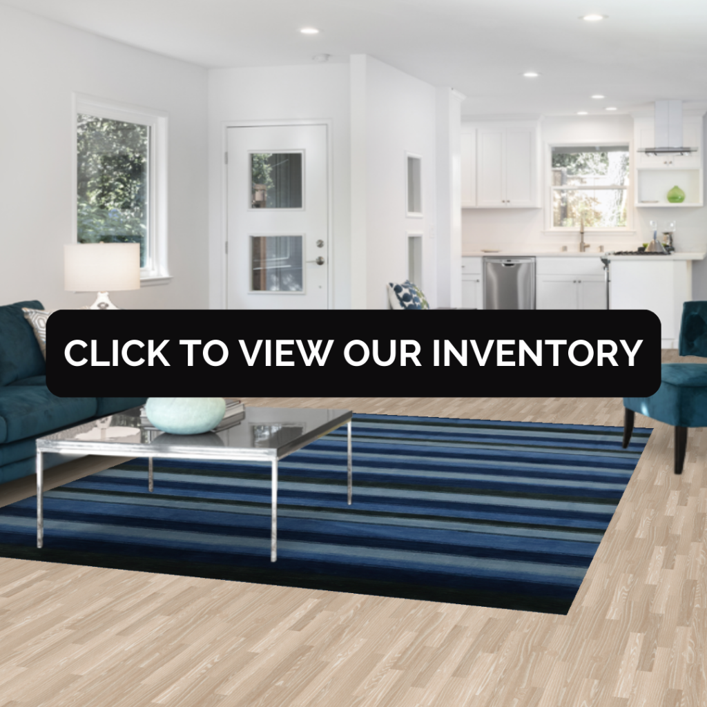 A modern living room with a deep blue striped rug under a glass coffee table and teal sofa.