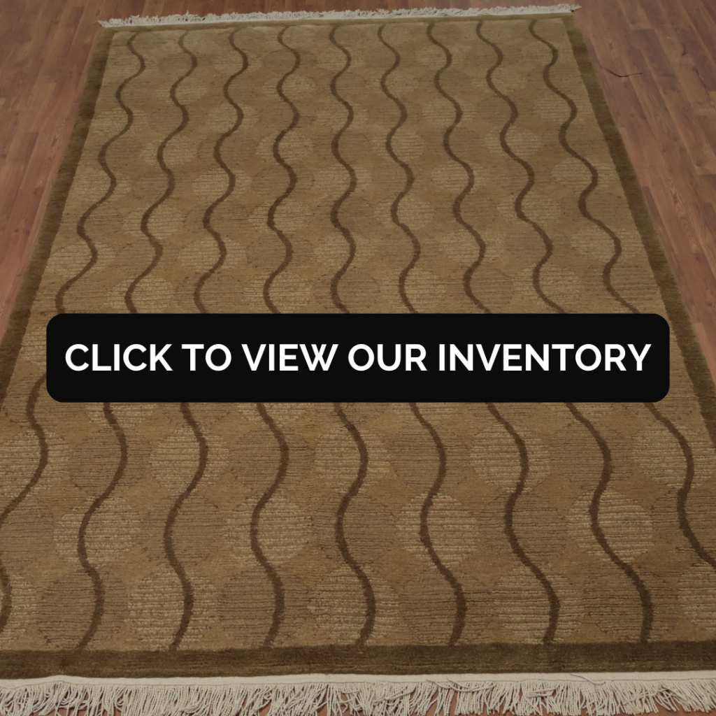 A tan rug with wavy brown line patterns and fringe on the edges displayed on hardwood flooring.