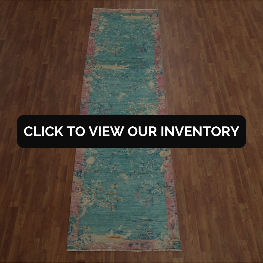 A long, narrow turquoise runner rug with pink edges and abstract floral patterns displayed on a wooden floor. Text overlay reads, “Click to view our inventory.”
