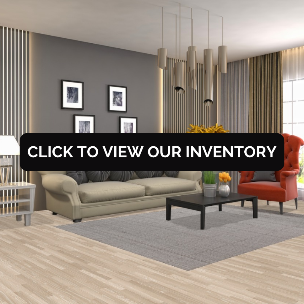 A contemporary living room features a beige sofa with circular charcoal pillows, a bold orange accent chair, and a sleek black coffee table. A large gray rug anchors the seating area against a dark feature wall with vertical slats and framed artwork. A centered black button reads “CLICK TO VIEW OUR INVENTORY.”