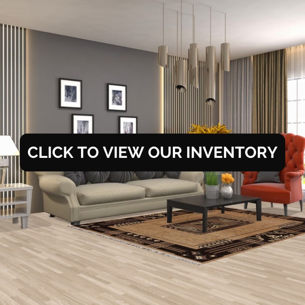 A stylish living room features a neutral sofa with circular charcoal pillows, a vibrant orange accent chair, and a modern black coffee table. Beneath the table is a tan rug bordered with bold dark brown geometric accents. A black “CLICK TO VIEW OUR INVENTORY” button is centered over the image.