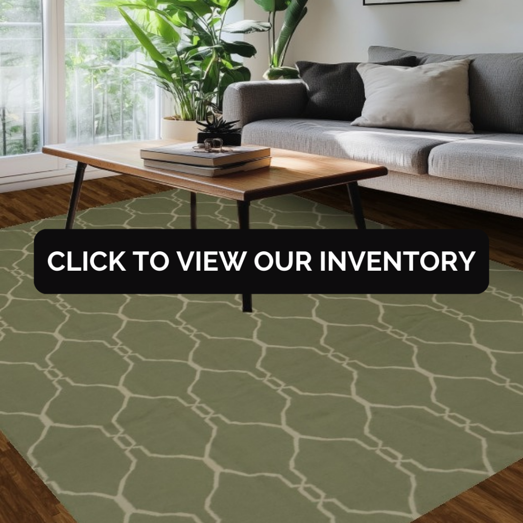 A modern living room features a gray sofa beside large windows filled with greenery. A wooden coffee table sits on a sage-green rug with an off-white geometric lattice pattern. A black overlay button reading “CLICK TO VIEW OUR INVENTORY” stretches across the center.