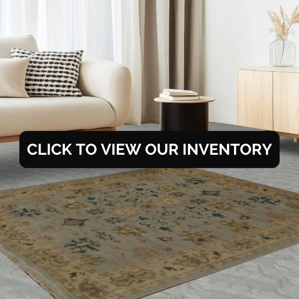 Minimalist living room featuring a neutral sofa and light wood furniture paired with a vintage-style area rug. The rug displays muted gold, blue, and beige patterns on a light stone floor.