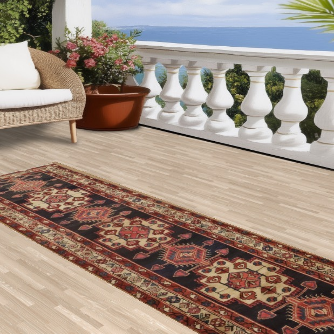 “Long patterned runner rug on a sunlit balcony overlooking the ocean, with white railing and greenery in the background.”