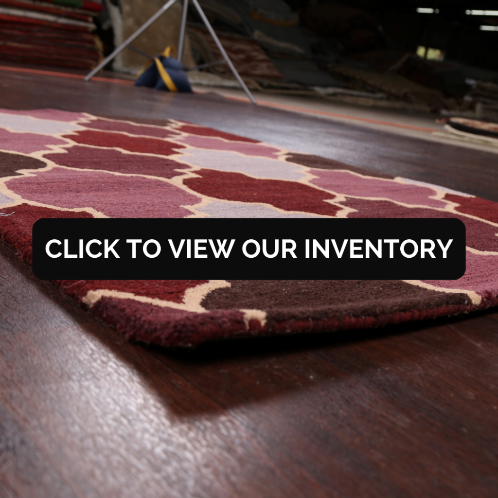 “Low-angle close-up of a patterned area rug on a dark wood floor. Black button reads ‘Click to View Our Inventory.’”