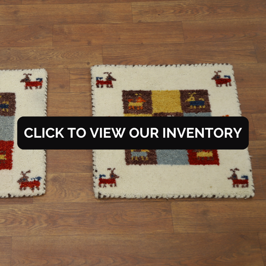 “Two small cream-colored accent rugs with geometric blocks and animal motifs on a wood floor. Black button reads ‘Click to View Our Inventory.’”