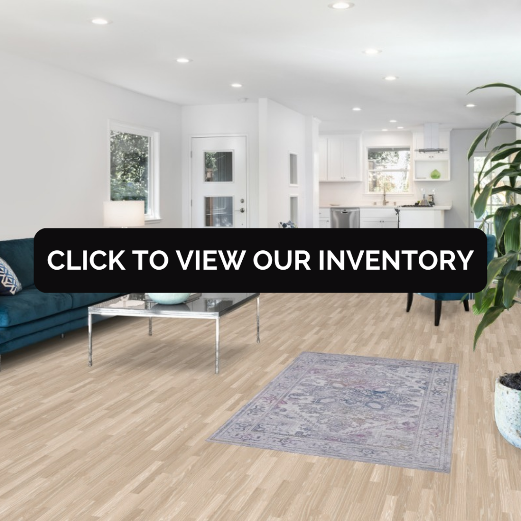 “Bright modern living room with light wood floors, teal seating, and a small patterned area rug centered in the space.”