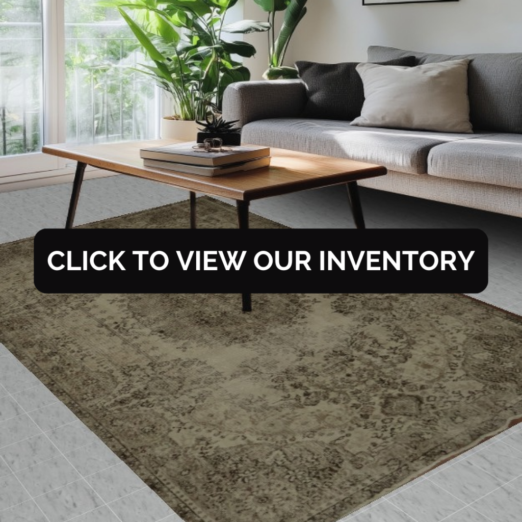 “Modern living room with gray sofa, wood coffee table, indoor plants, and a neutral-toned area rug. Black button reads ‘Click to View Our Inventory.’”
