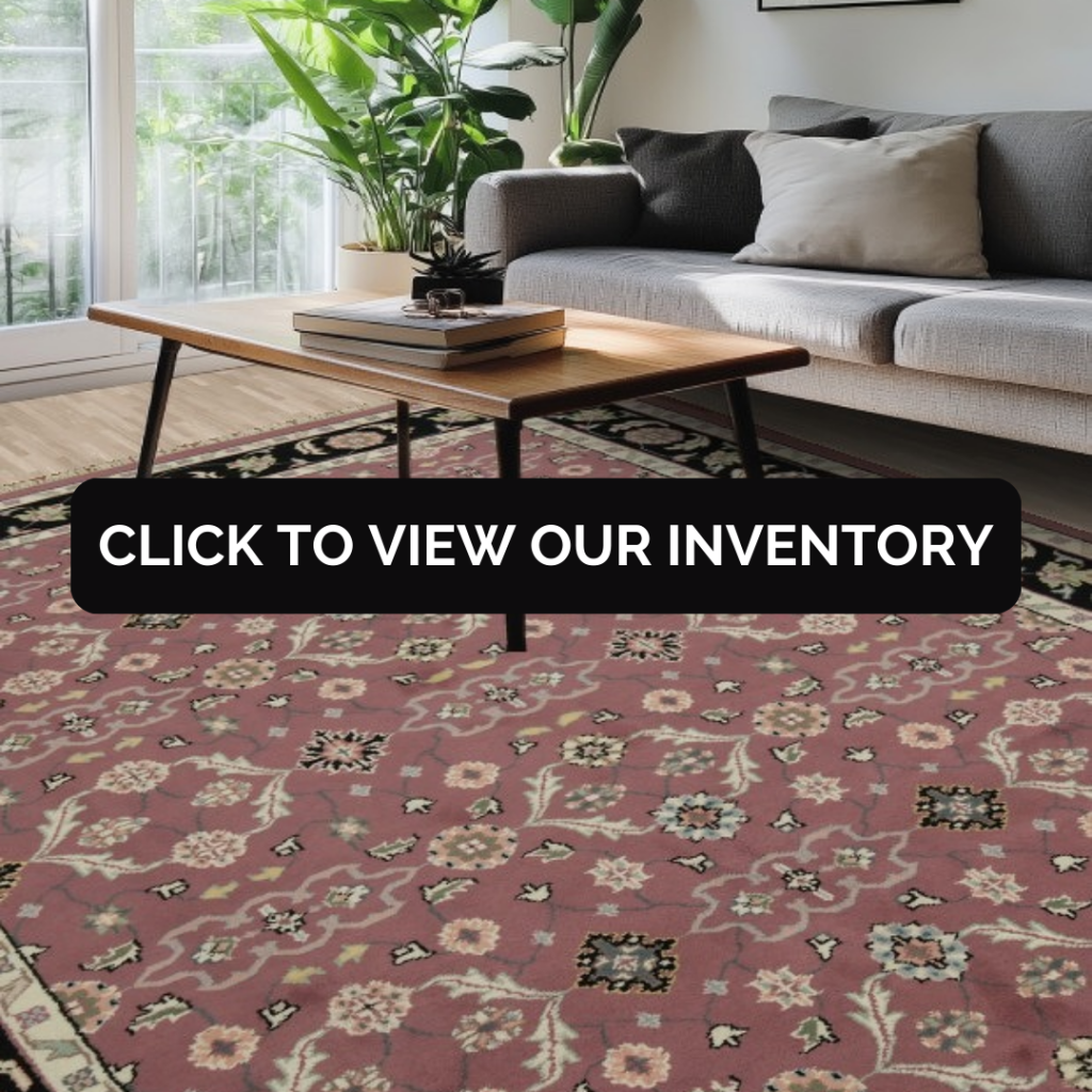 “Living room with gray sofa, wood coffee table, indoor plants, and a red patterned area rug. Black button reads ‘Click to View Our Inventory.’”