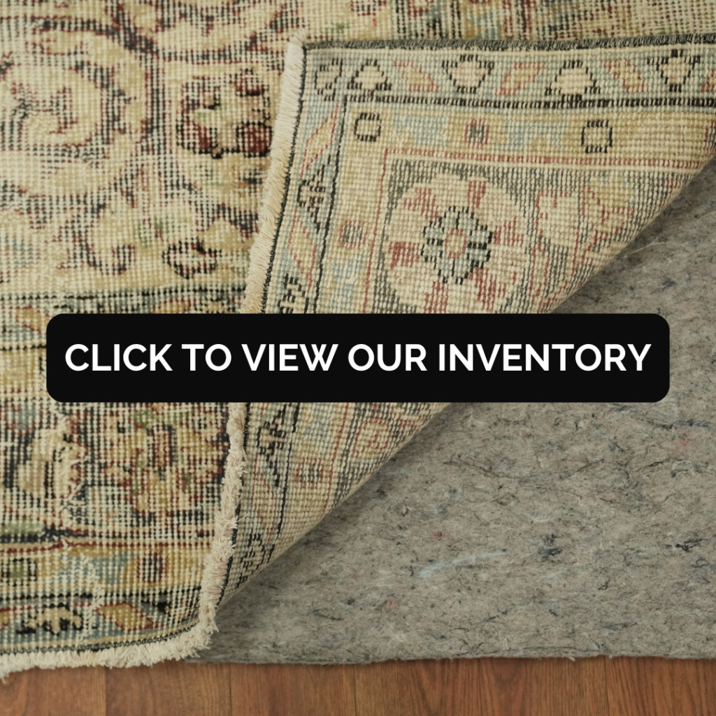 A close-up of a rug corner folded back shows the detailed backing and stitched border with a gray rug pad underneath. The intricate pattern and fringe edge are visible along the fold.