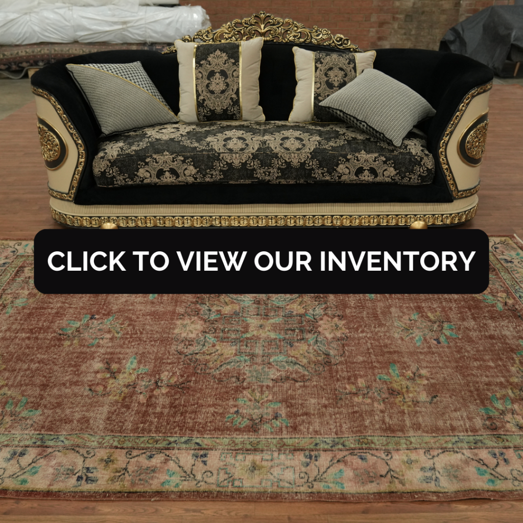 A corner of a patterned rug is lifted to reveal the underside weave and gray rug pad beneath. A black banner across the center reads, “CLICK TO VIEW OUR INVENTORY.”