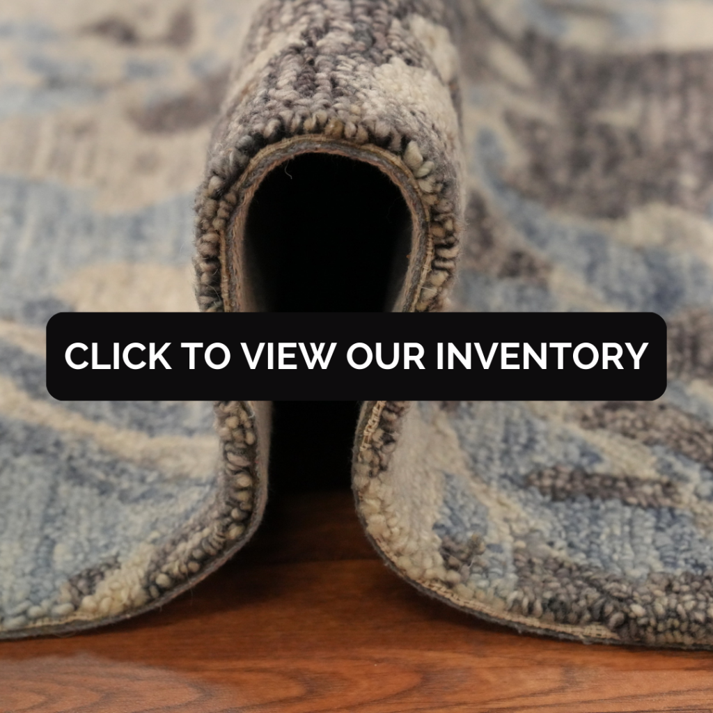 A close-up of a rolled rug shows the thick woven pile and layered backing, revealing its texture and construction. A black banner across the center reads, “CLICK TO VIEW OUR INVENTORY.”