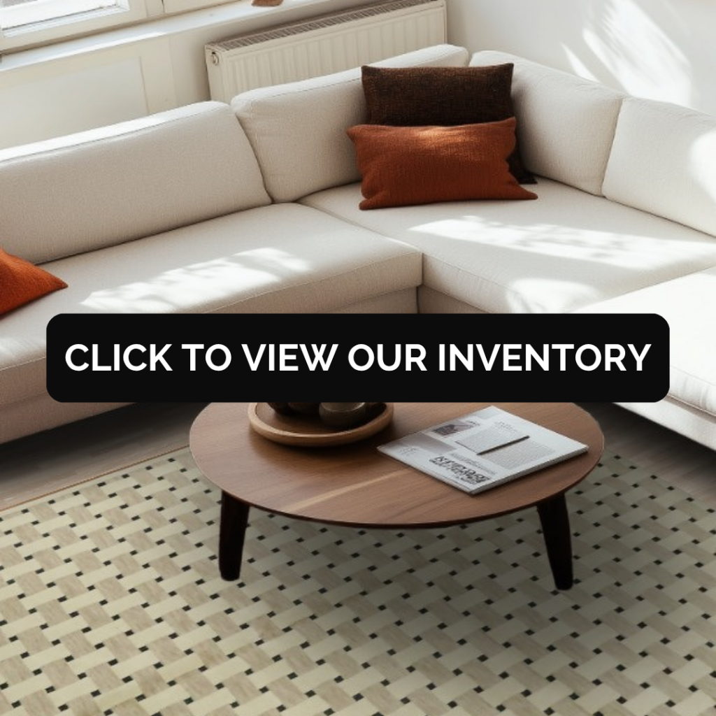 A cozy living room with a cream sectional sofa, round wooden coffee table, and neutral decor, set on a light patterned rug with small geometric details. A bold black banner across the center reads “Click to view our inventory.”