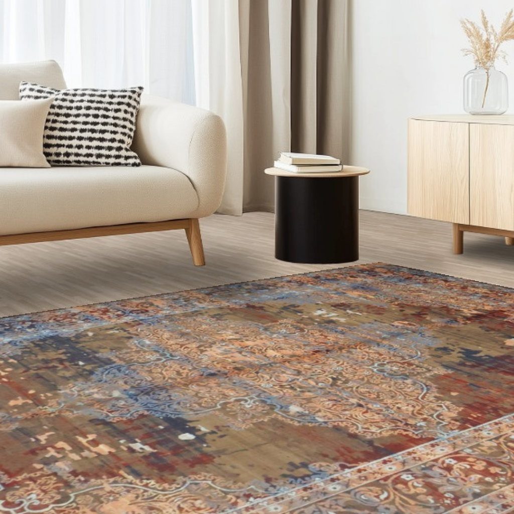 A bright, minimalist living room with a cream sofa, small round table, and neutral decor, showcasing a distressed multicolor rug with intricate patterns. Soft natural light highlights the warm tones of the space.