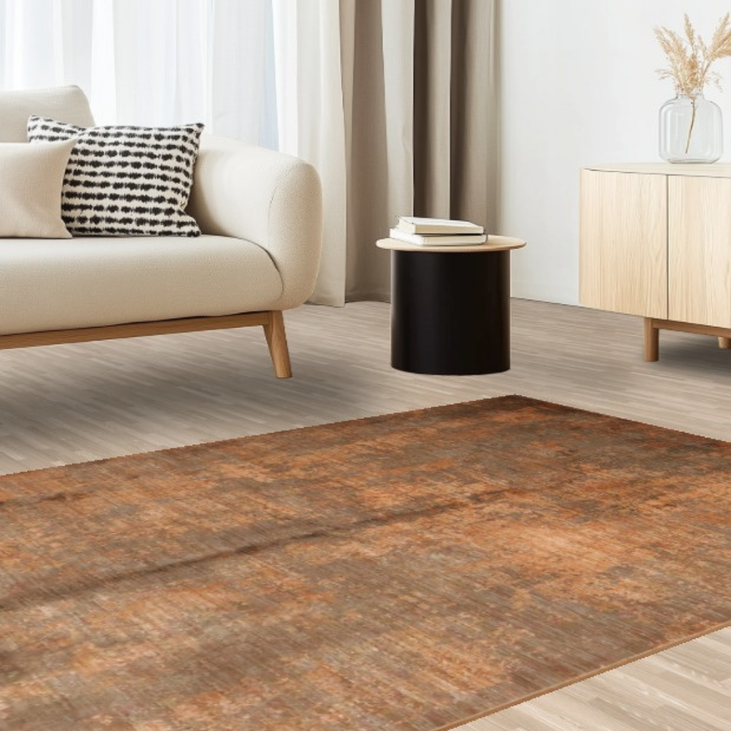 A clean, modern living space with a cream sofa, side table, and light wood cabinet, showcasing a textured brown rug with a worn, vintage look. The neutral palette creates a calm, cohesive atmosphere.