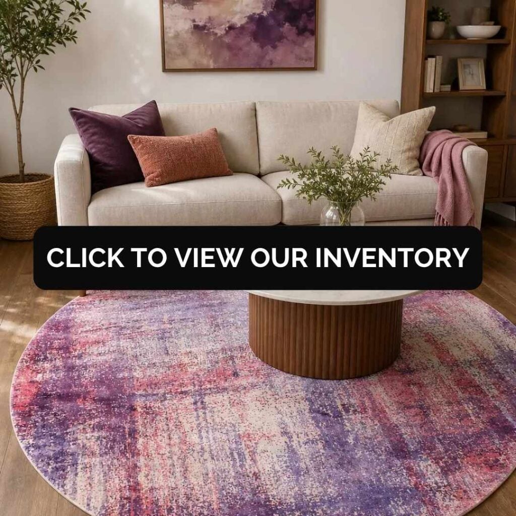 Modern living room featuring a round purple abstract area rug beneath a white marble coffee table and neutral sofa with a "Click to View Our Inventory" banner.