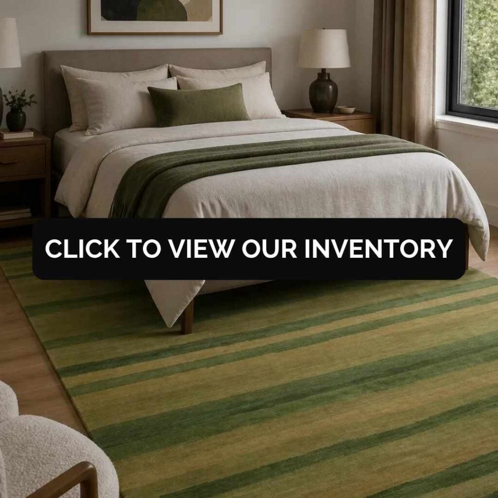 Contemporary bedroom with a green striped area rug beneath a neatly styled bed and a "Click to View Our Inventory" banner.